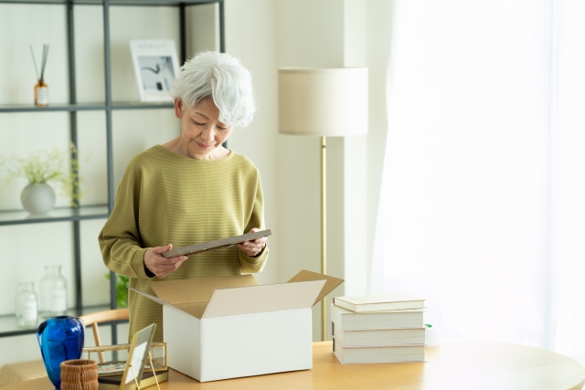 堺市で家族葬を終えた後、遺品を分類しながら段階的に整理を進めていく家族の手元の様子